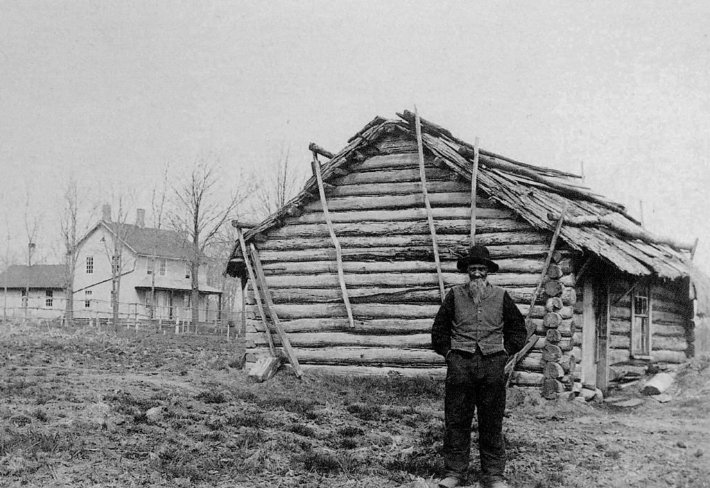 Andrew Peterson standing on his farm in the 1800s