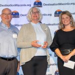 A group of people smiling with an award