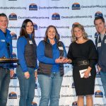Group of people smiling with award