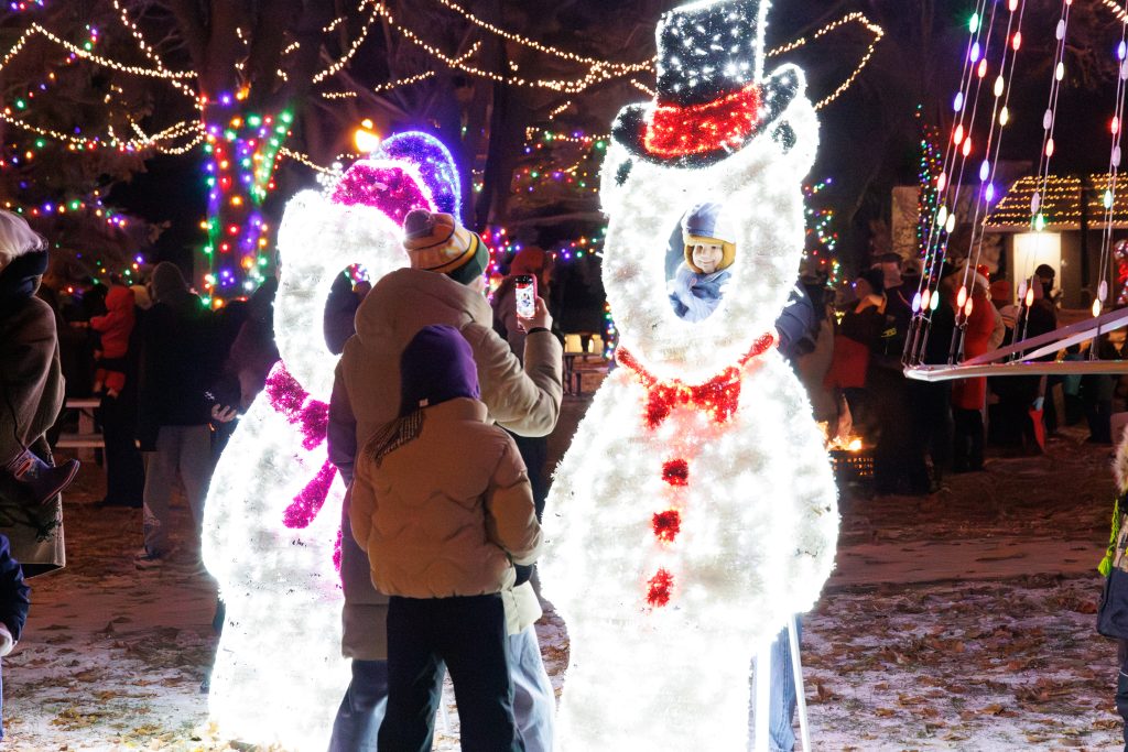 A family taking a picture in a Santa bears light up photo op