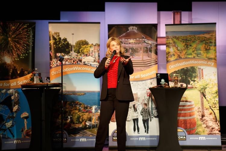woman on stage speaking into a microphone